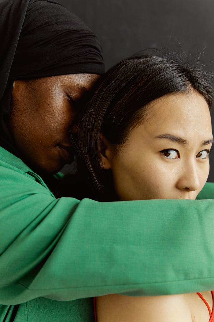 A Person  in Green Long Sleeve Shirt Hugging a Woman from Behind